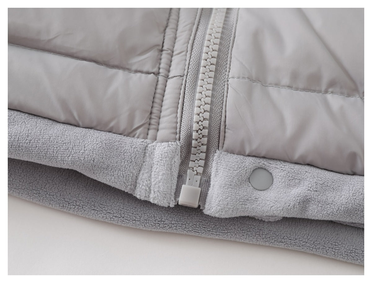 Close-up of the vest's lower zipper and snap fastening above a soft gray fleece-lined hem.
