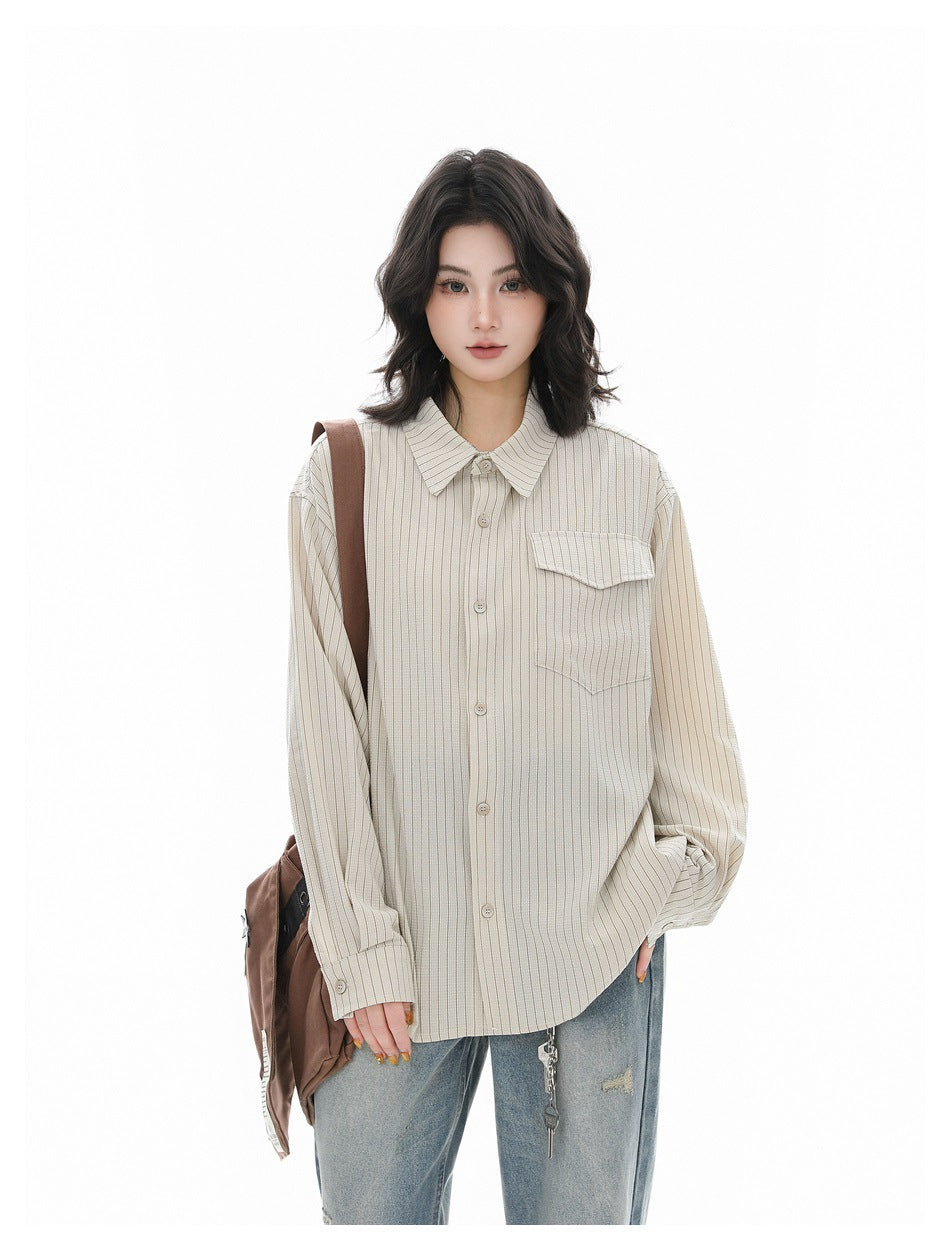 Model wearing apricot pinstripe button-up shirt with jeans and a brown shoulder bag, three-quarter view