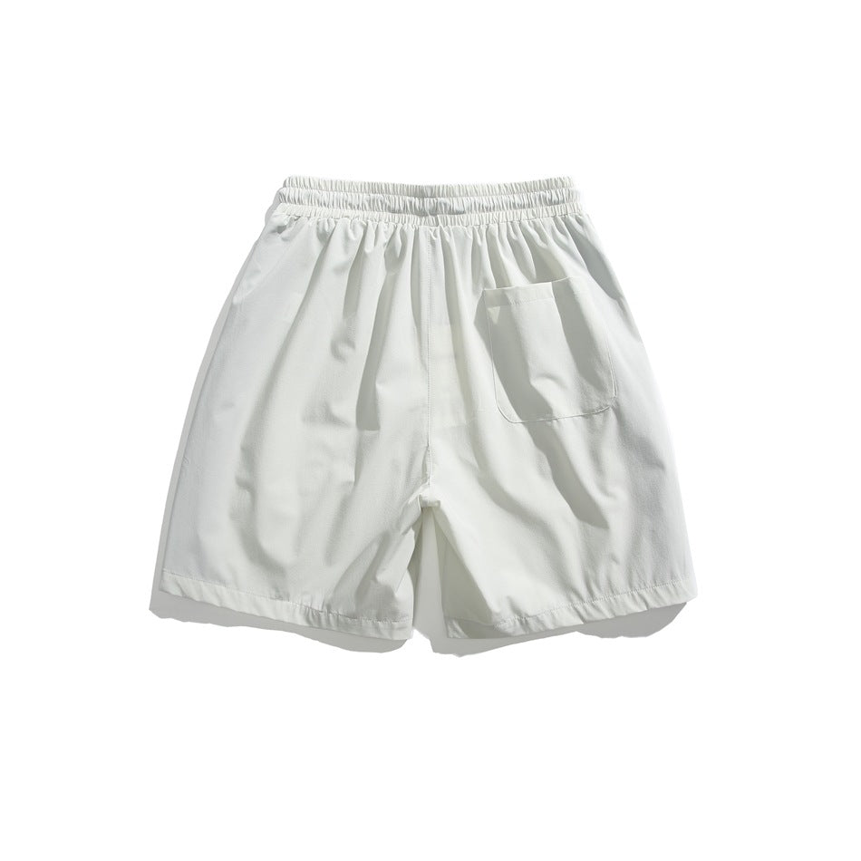 Back view of white shorts with an elastic waistband and a single patch pocket.