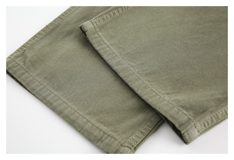 Close-up of olive-khaki garment panels with double-stitched hems and folded edges.