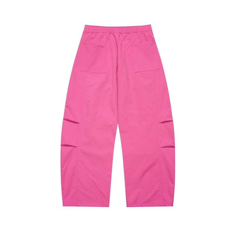 Back view of bright pink wide-leg pants with an elastic waistband and two rear patch pockets.