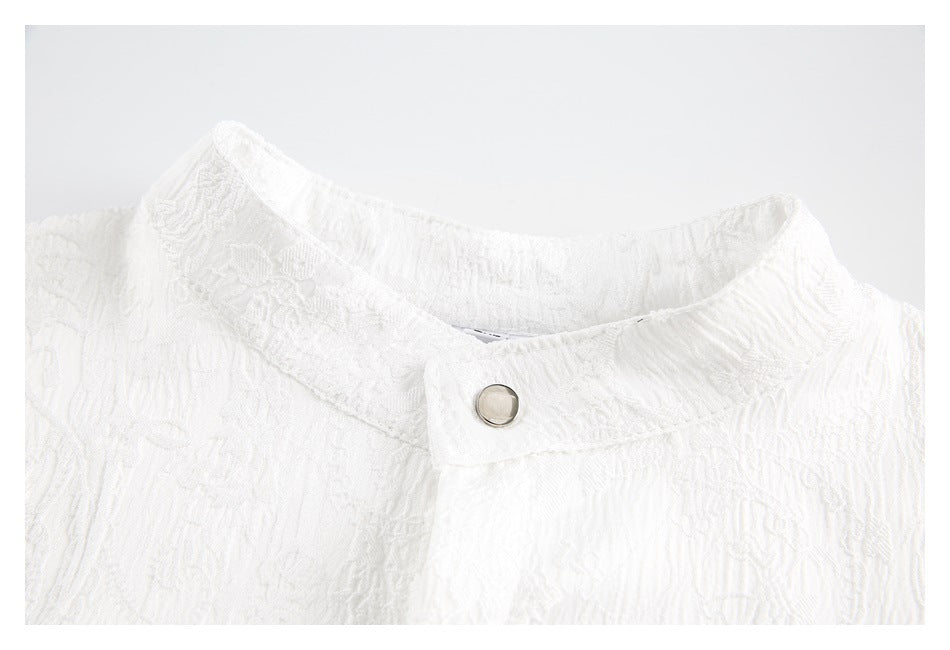 Close-up of the white shirt's textured stand collar and silver snap button.