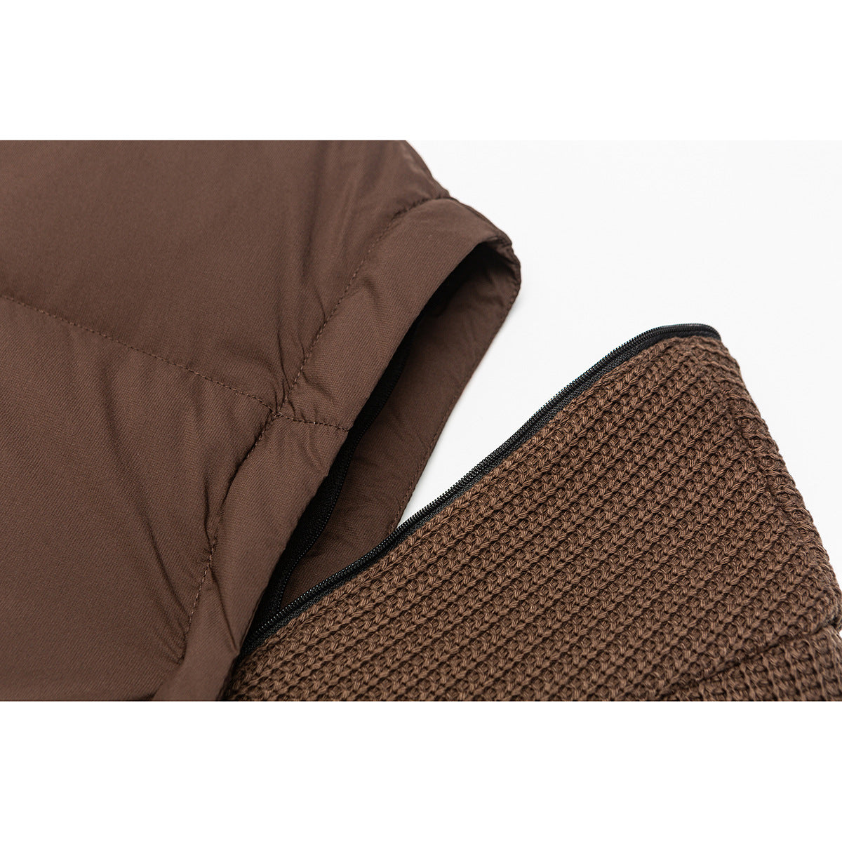 Close-up of a brown jacket sleeve opening beside a separate textured brown knit panel and zipper edge.