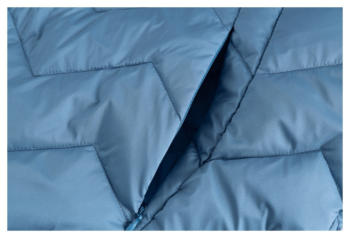 Close-up of blue quilted jacket panels and a partially open zipper between them.