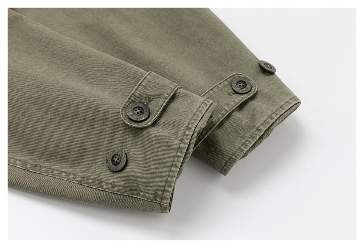 Close-up of olive-gray garment cuffs with dark buttons and button tabs.