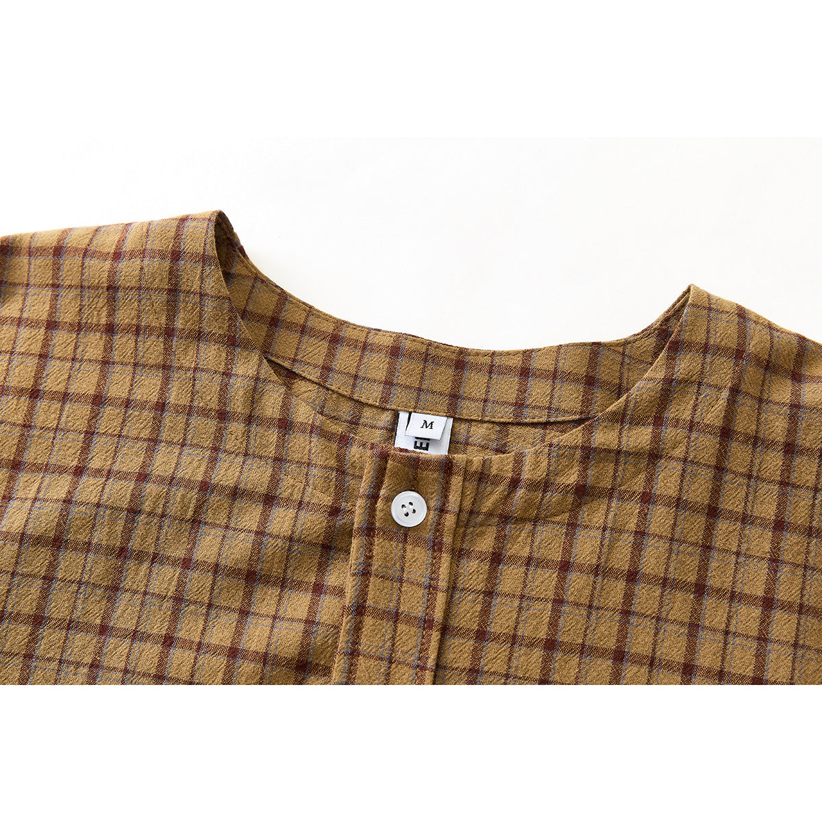 Close-up of a brown plaid shirt's rounded neckline, white button, and small sewn label.
