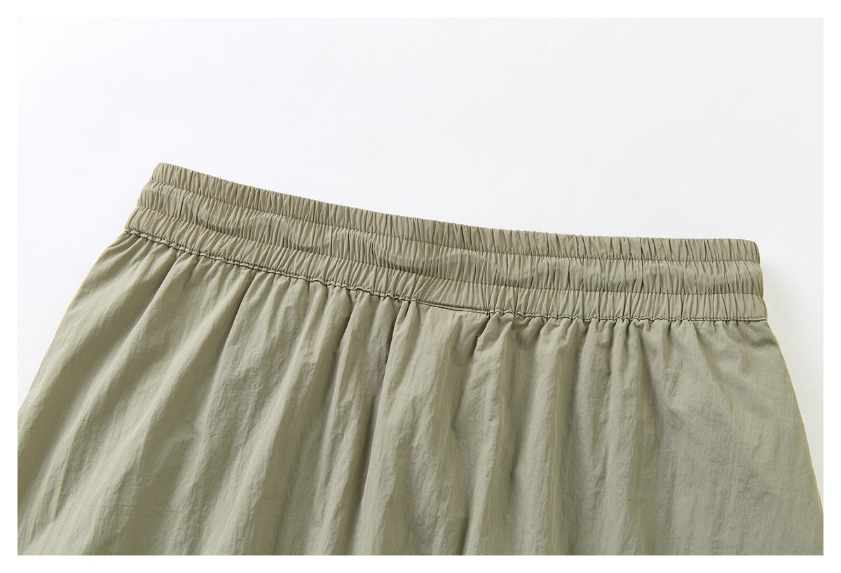 Close-up of the wide gathered elastic waistband on khaki shorts.