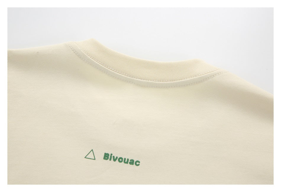 Ivory garment neckline with a small green triangle and Bivouac print below the collar.