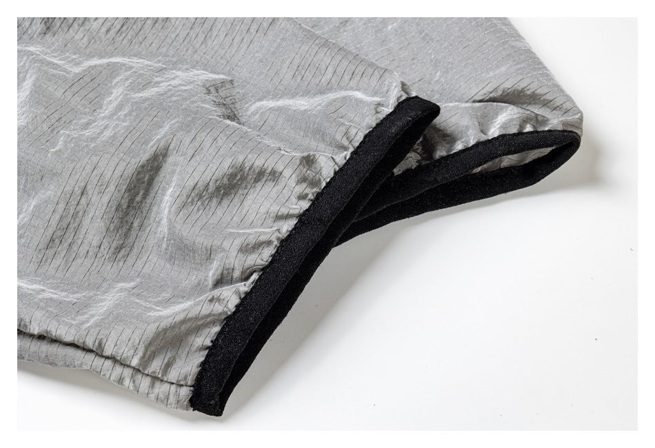 Close-up of gray striped fabric with a black bound edge.