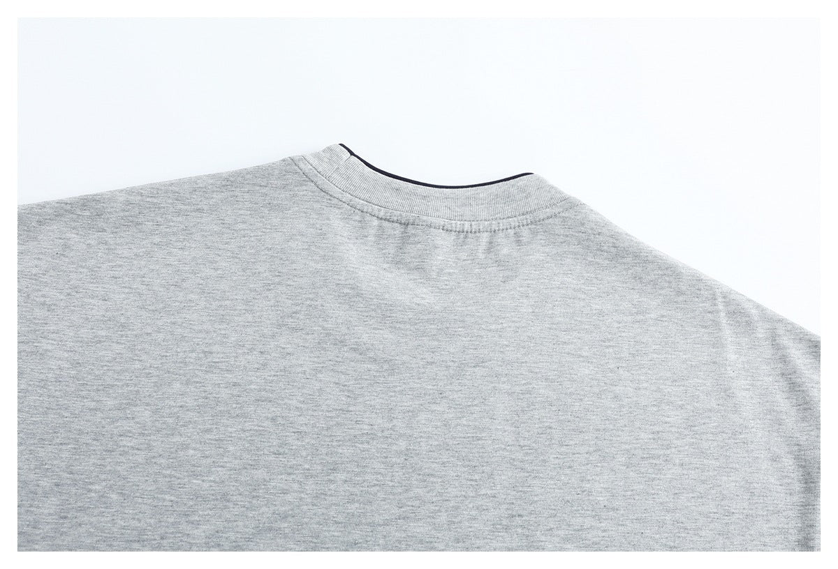 Close crop of the upper back of a light gray T-shirt, showing its crew neckline and shoulder seams.