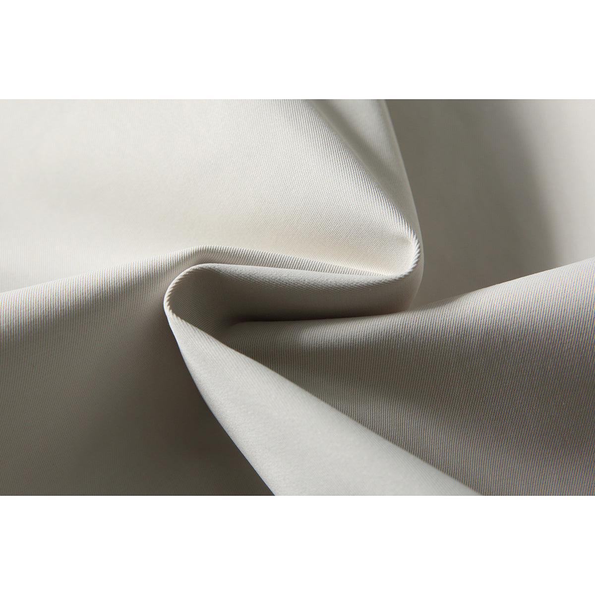 Close-up showing the fine surface texture and folded fabric of an off-white jacket.