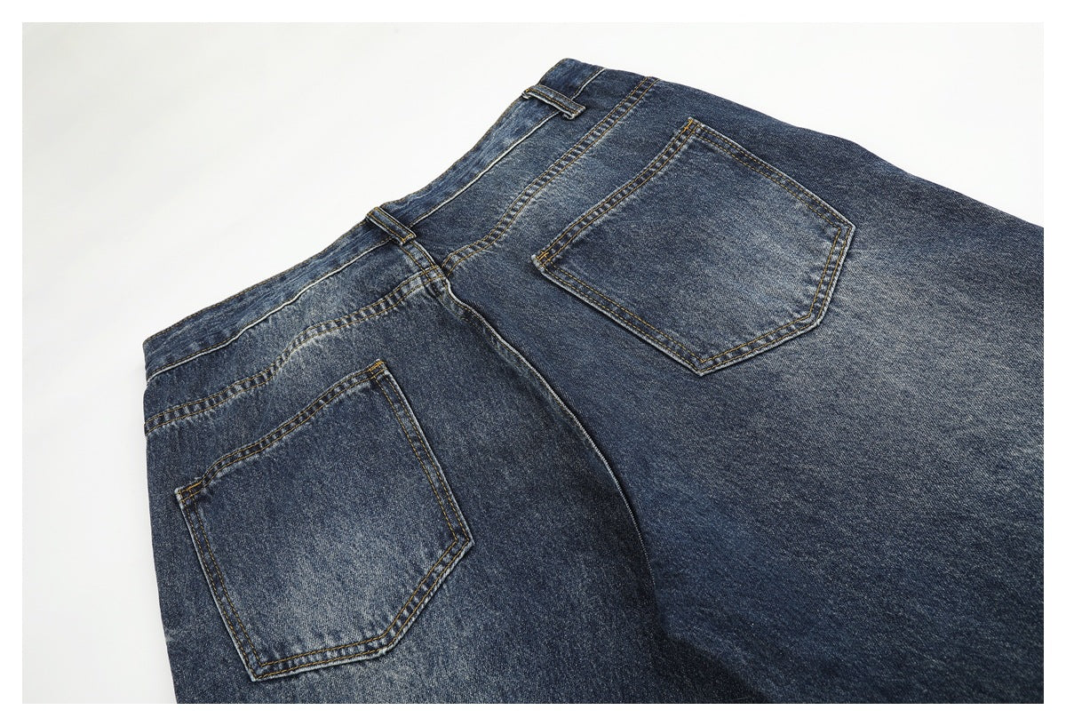 Back view of dark blue jeans laid flat, showing the waistband, belt loops, and two pockets.