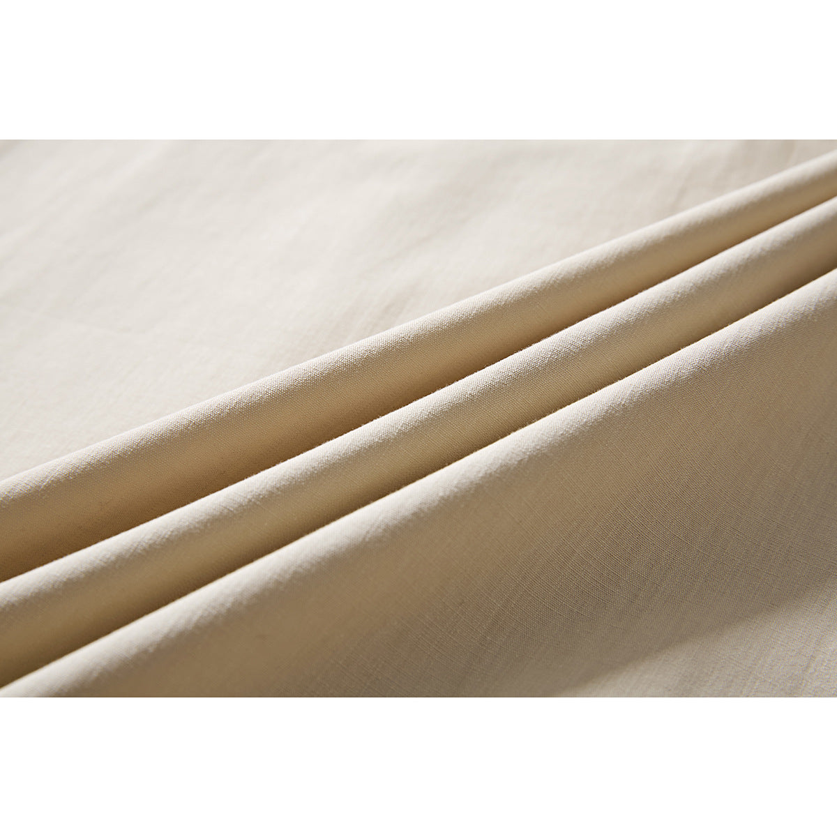 Close-up of beige shirt fabric arranged in folds, showing its surface and texture.