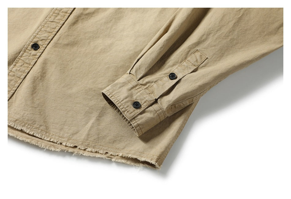 Close-up of a buttoned cuff and frayed hem on the tan shirt.