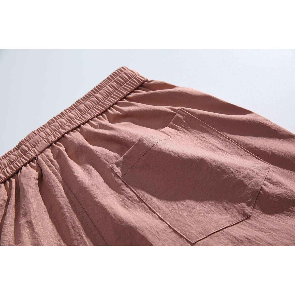 Close-up of the dusty rose pants' elastic waistband and large rear patch pocket.