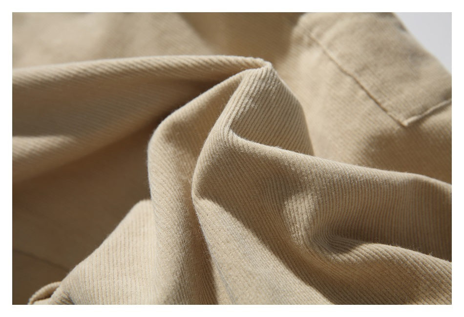 Close-up of the fine ribbed texture and stitching on tan corduroy pants.