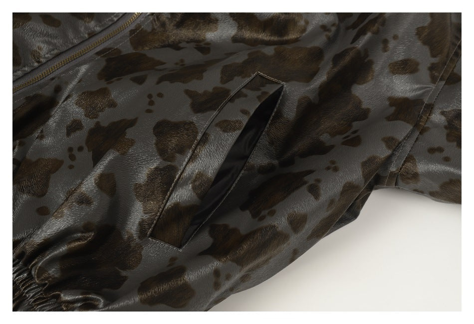 Close-up of a narrow slit pocket on glossy gray-brown spotted garment fabric.