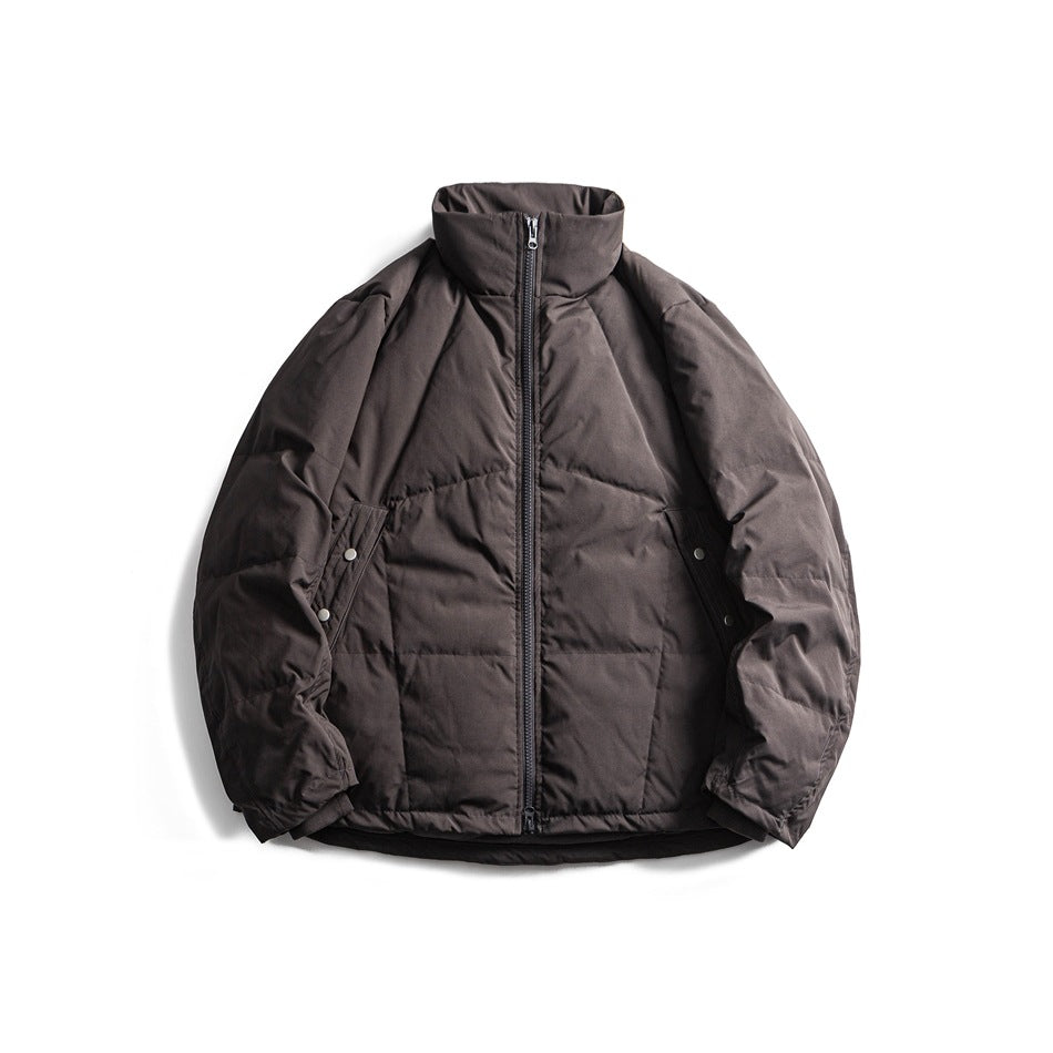 Dark gray quilted stand-collar puffer jacket with front zipper and snap side pockets, flat lay front view