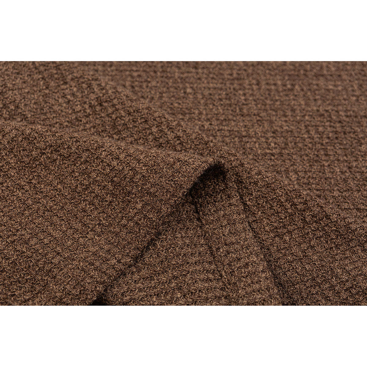 Close-up of brown knit fabric showing a folded seam and textured weave.