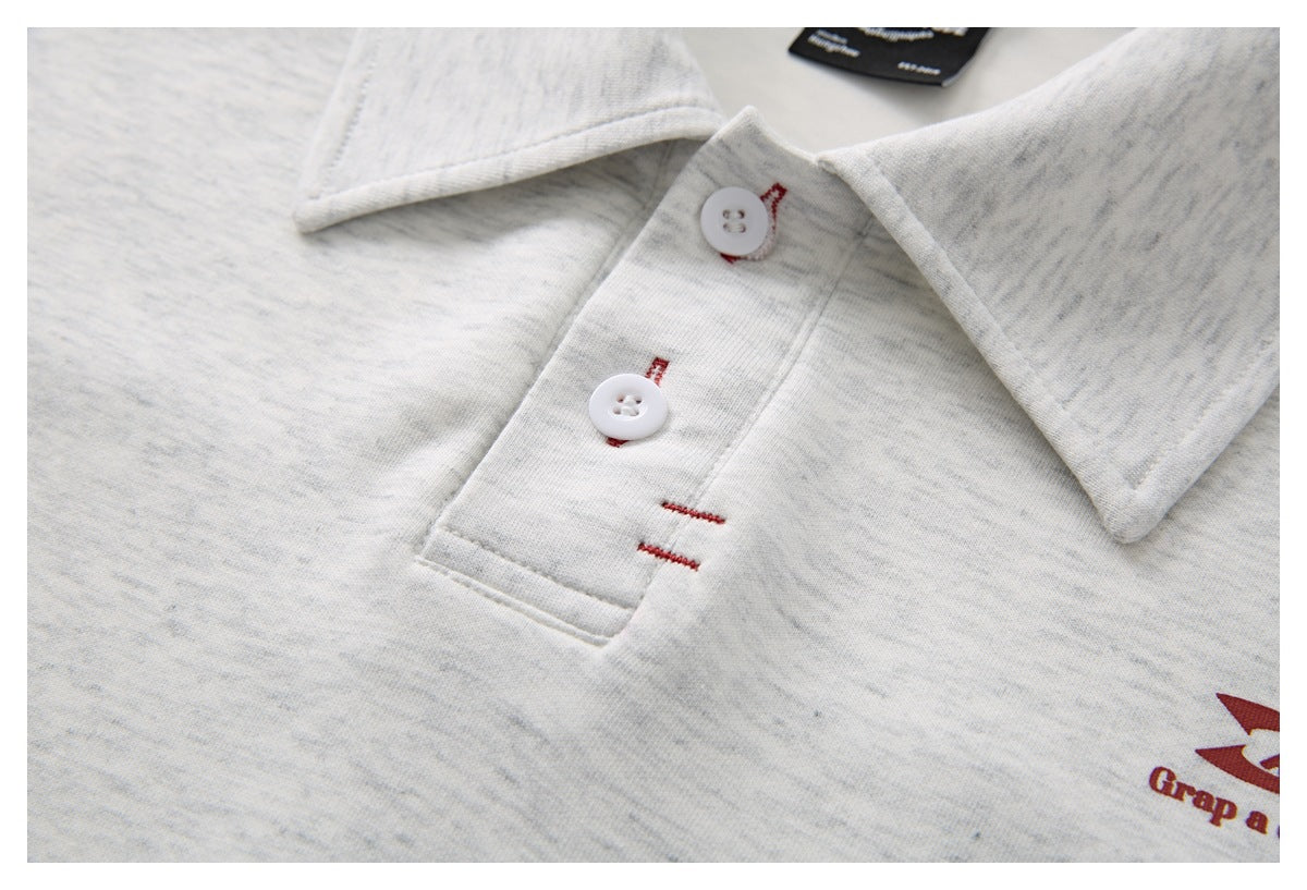 Close-up of the light gray heather polo collar and white-button placket, with part of the maroon chest graphic visible.