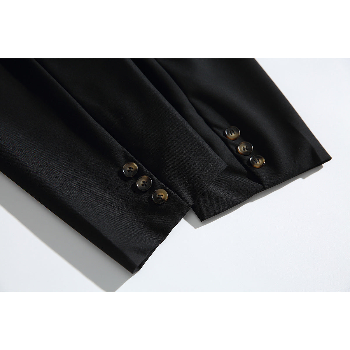 Close-up of the black blazer's sleeve cuffs with three buttons on each sleeve.