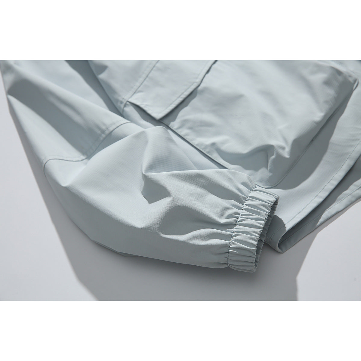Close-up of a pale blue jacket sleeve with a gathered elastic cuff.