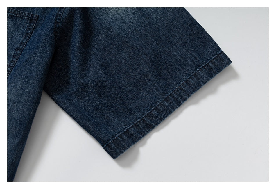 Close-up of a dark blue denim sleeve edge with a wide stitched hem.