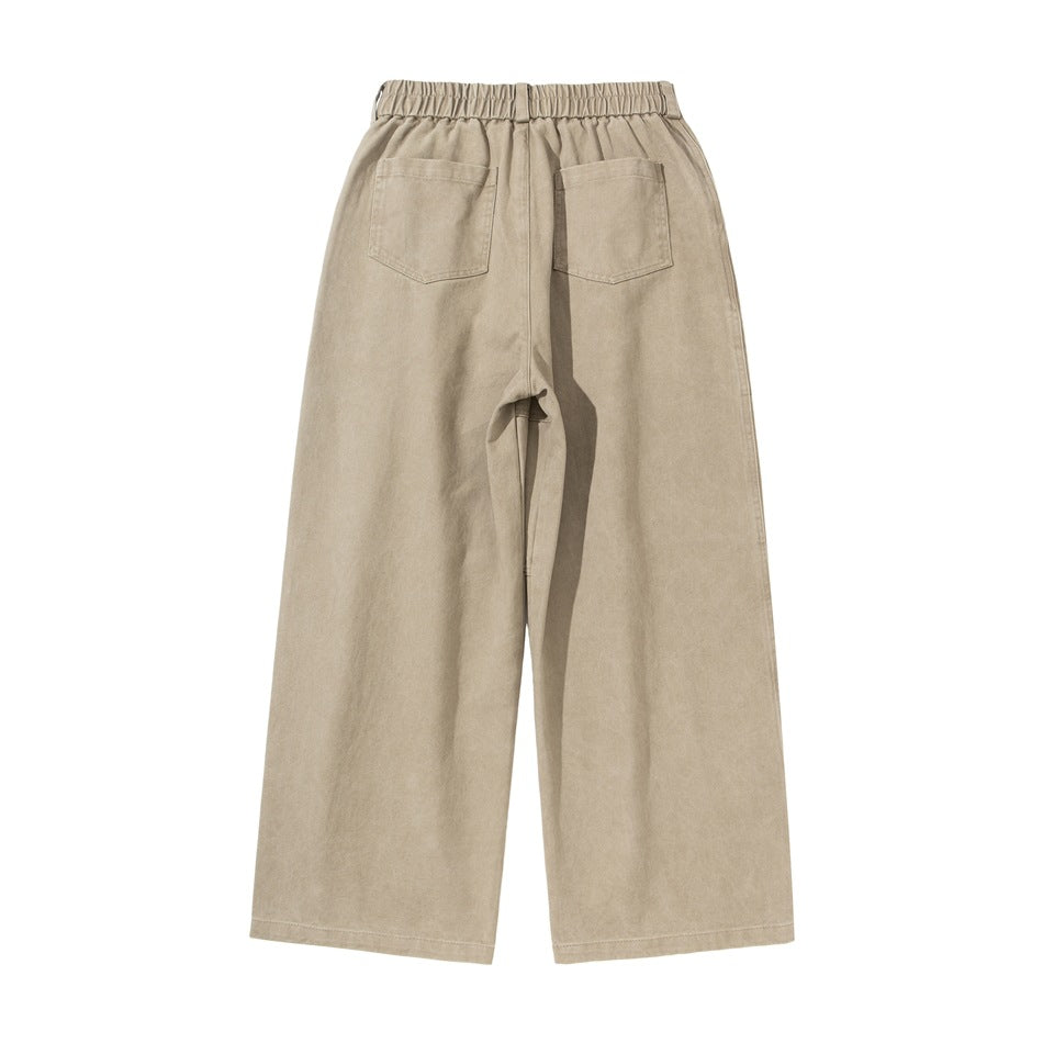 Back view of light beige wide-leg trousers with an elastic waistband and two rear patch pockets.