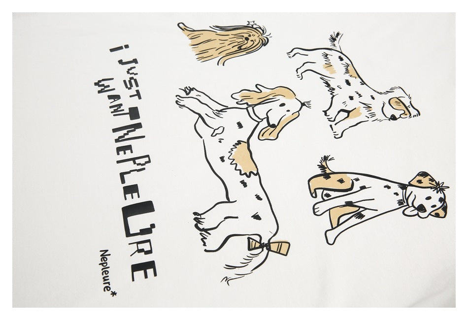 Close-up of a white shirt print with several cartoon dogs and a bold English slogan.
