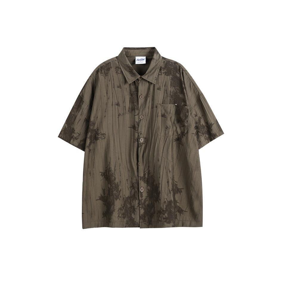 Brown-gray short-sleeve button-up shirt with crinkled texture, chest pocket and dark bamboo-leaf print, flat lay