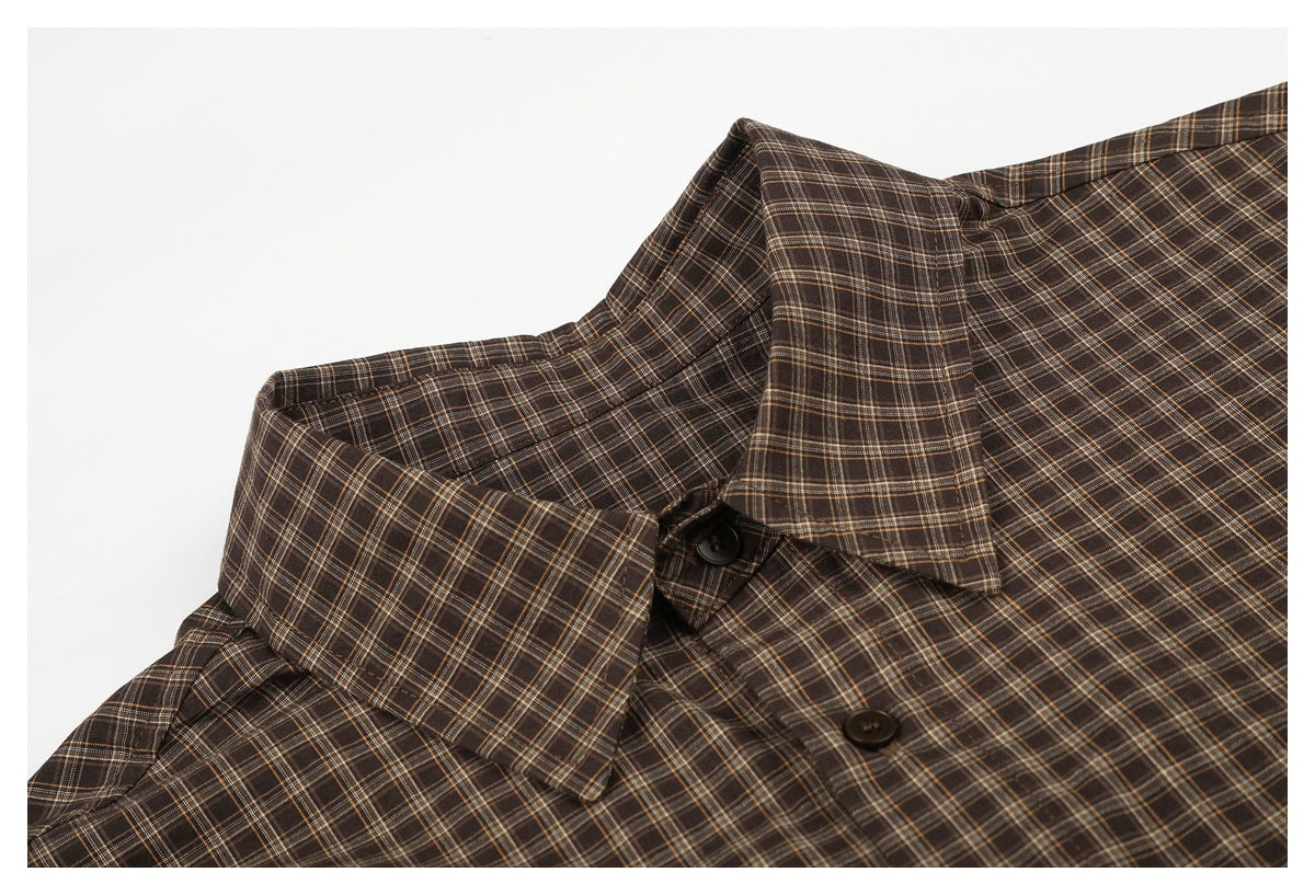 Close-up of a brown plaid shirt collar and dark front buttons.