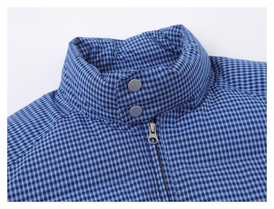 Close-up of a blue checked jacket collar with two snap buttons and a front zipper.