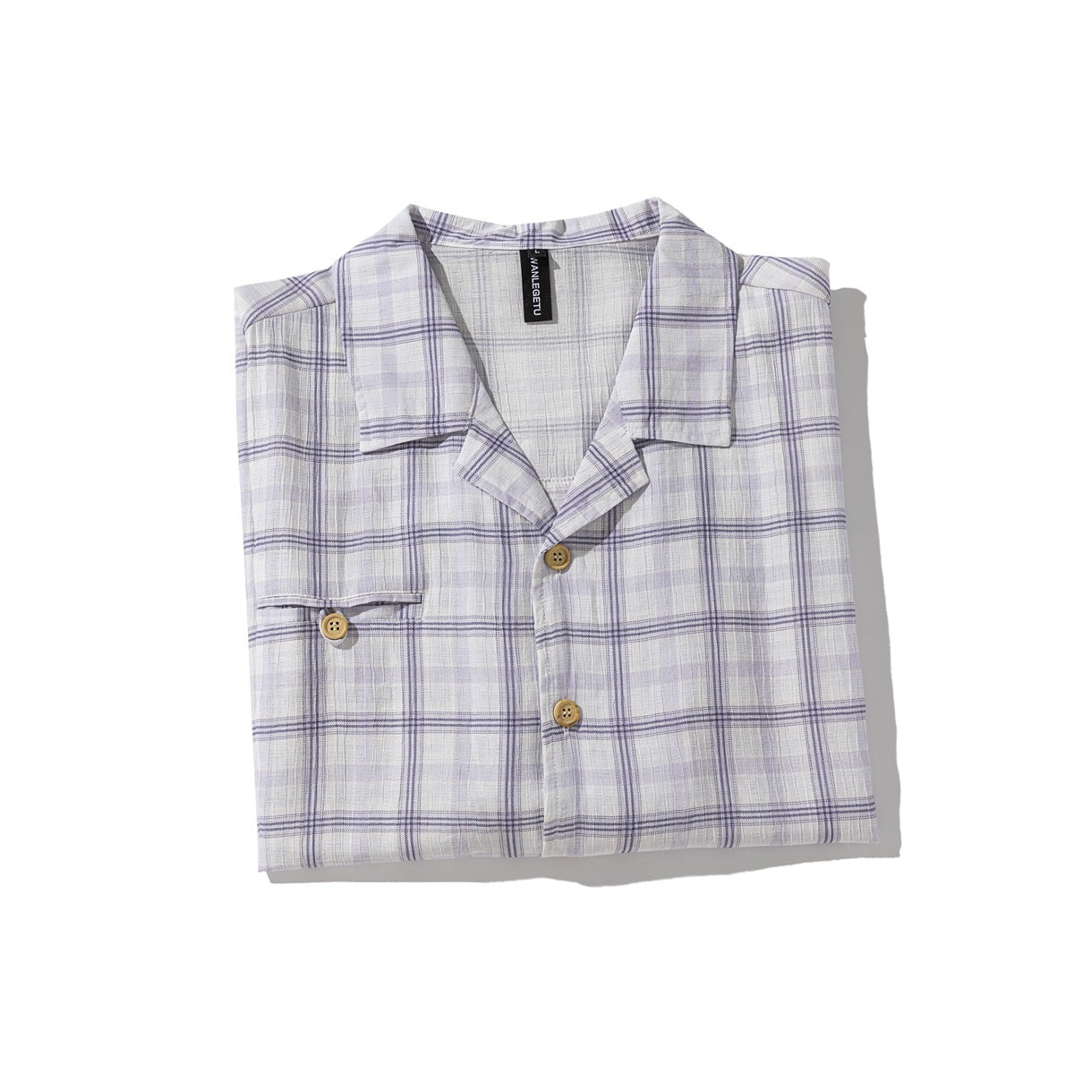 Folded pale lavender and white plaid short-sleeve shirt with an open collar, wooden buttons, and a chest pocket.