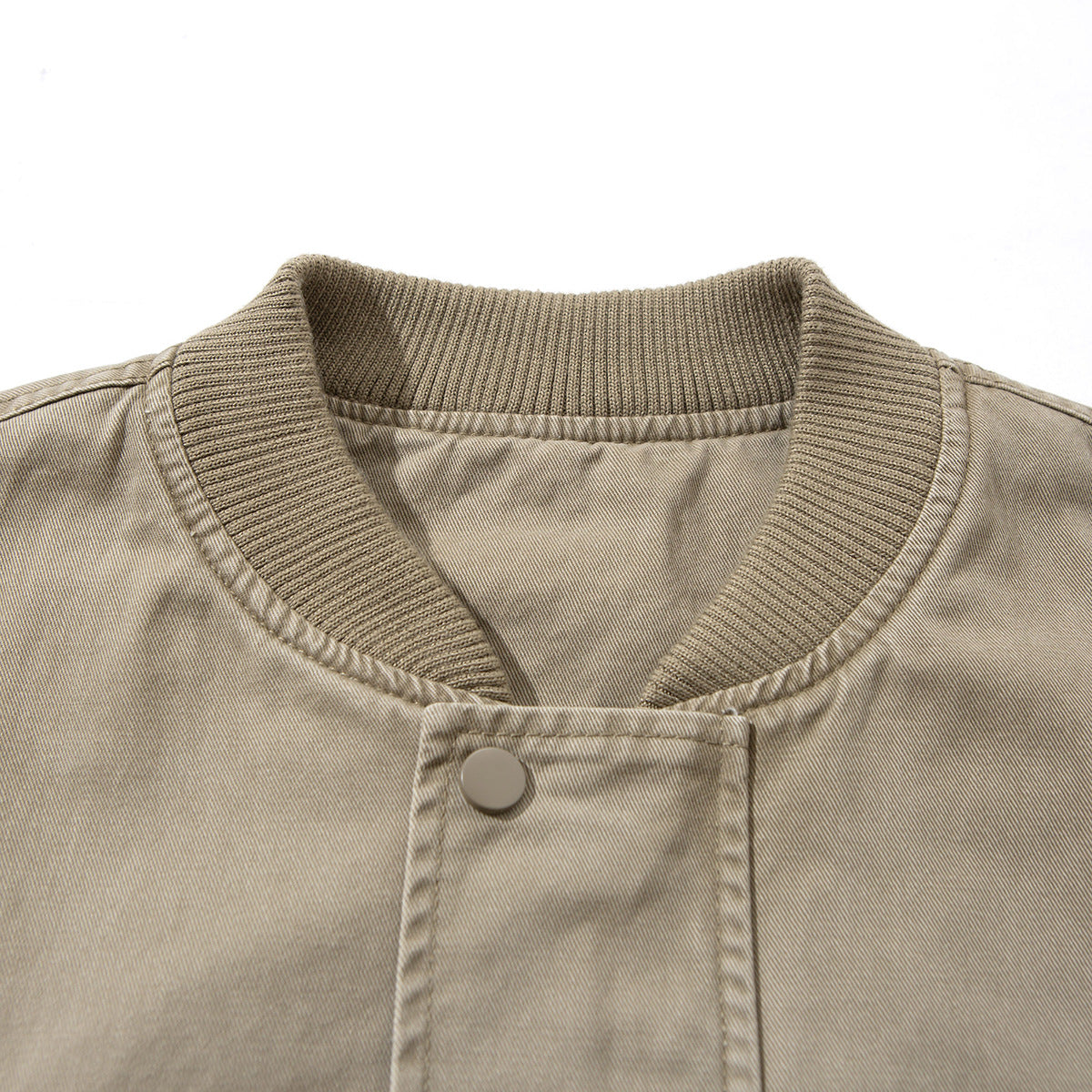 Close-up of a taupe jacket's ribbed stand collar and single snap-fastening front placket.