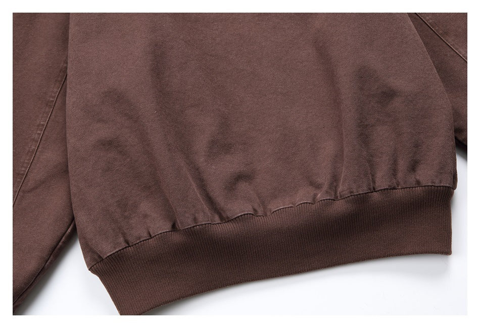 Close-up of a brown garment's gathered fabric meeting a wide ribbed band.