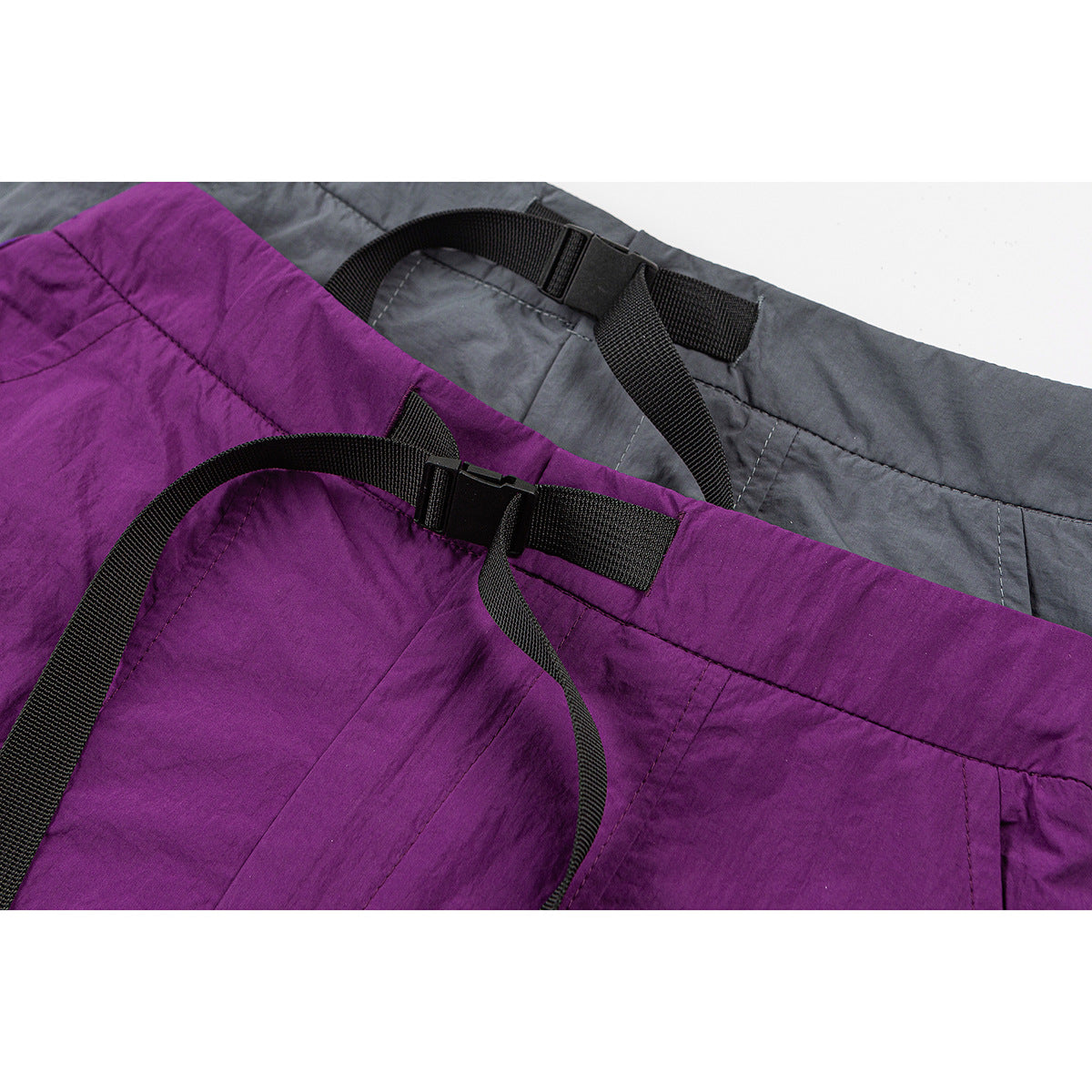 Close-up of purple and gray skirts showing adjustable black webbing waist straps and buckles.