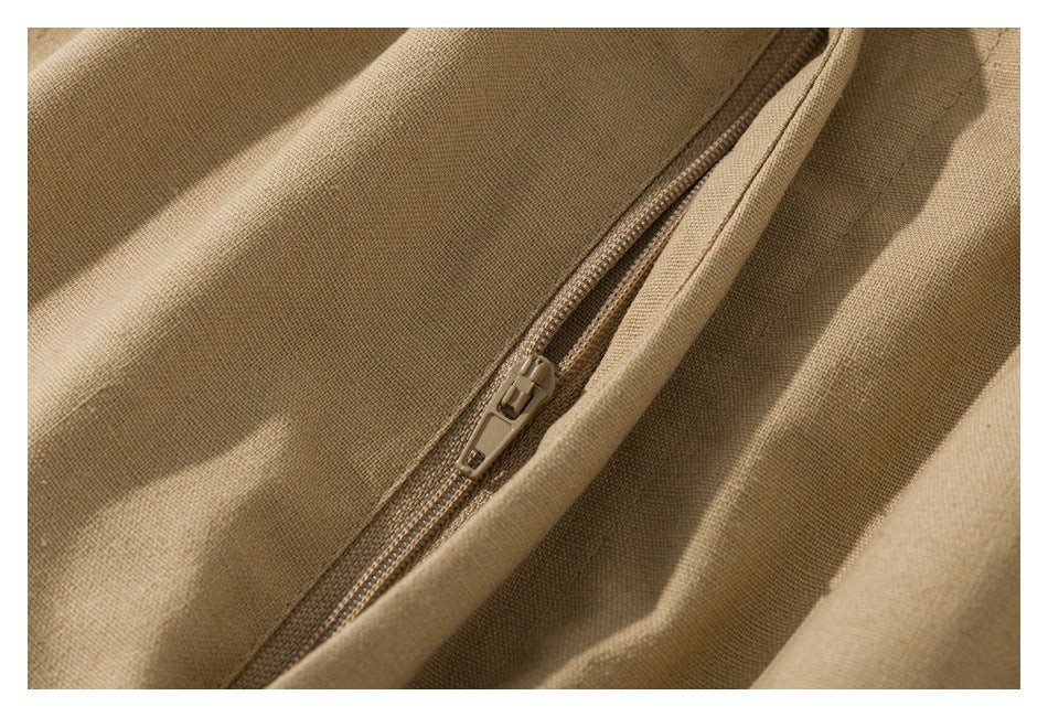 Close-up of a tan pants pocket zipper and surrounding stitching.