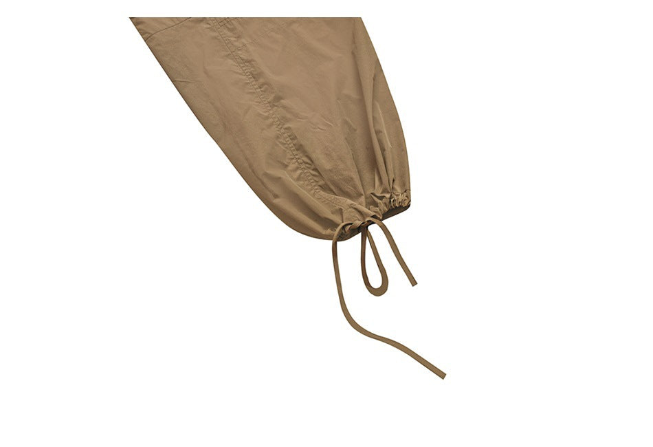 Close-up of a tan pant leg gathered at the ankle with an adjustable tie cord.