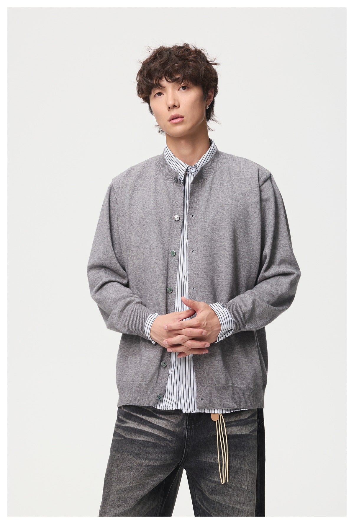 Front view of a model wearing a gray button-front cardigan over a striped shirt.