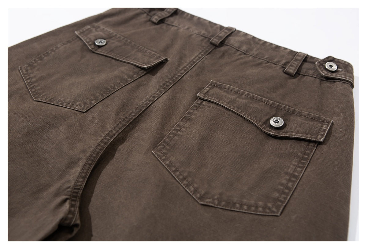 Close view of brown trousers with two button-flap back pockets and belt loops.