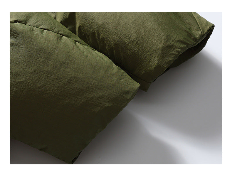 Close-up of overlapping olive-green padded jacket sections and stitched seams.