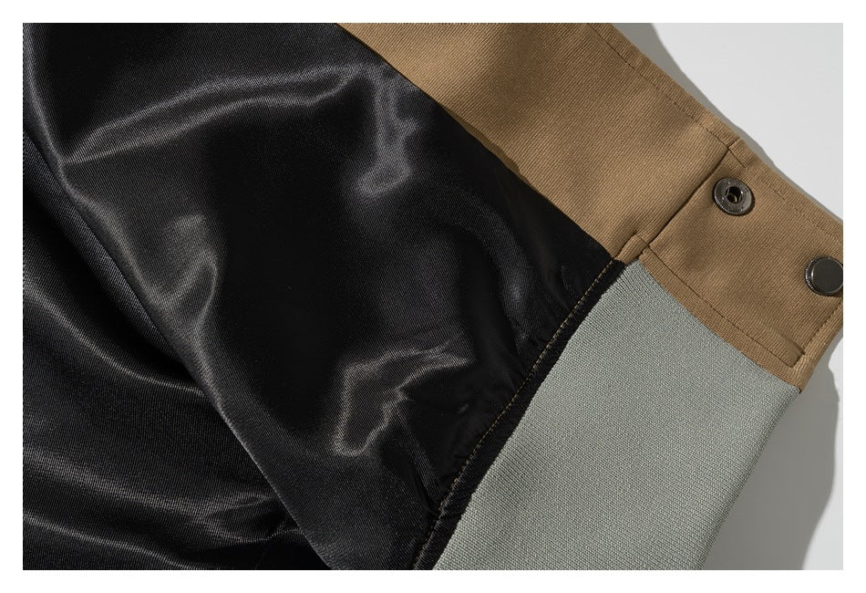 Close-up of the tan jacket's black inner lining, snap fasteners, and gray-green hem trim.