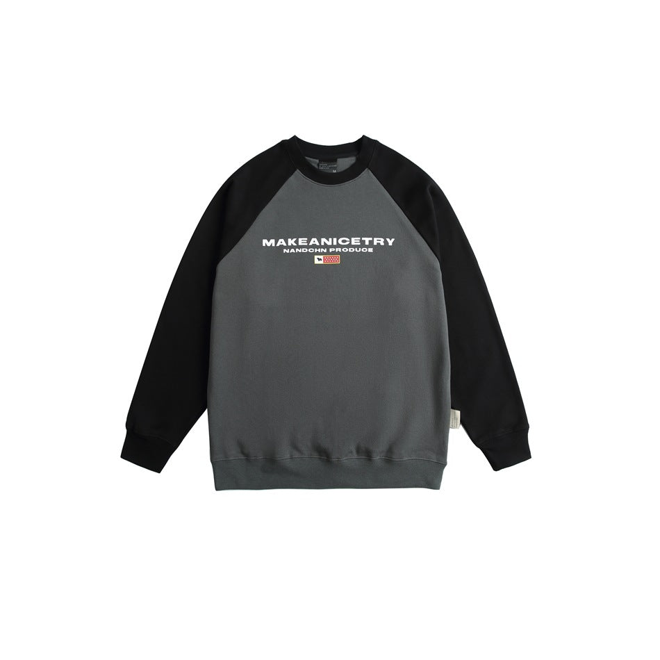 Gray crewneck sweatshirt with black raglan sleeves and collar, white chest print and small flag graphic, flat front view