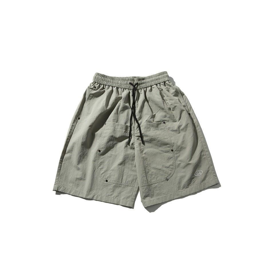 Gray-green knee-length shorts with drawstring waist, large front patch pockets with studs and small oval logo