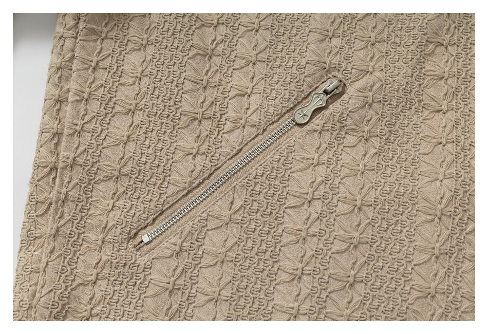 Diagonal silver zipper on beige fabric with raised floral stitching and ribbed bands.