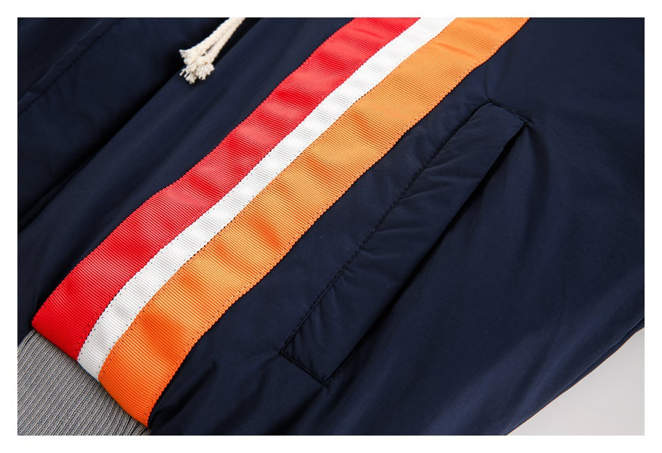 Close-up of the jacket's red, white, and orange stripes beside a navy pocket and gray ribbed hem.
