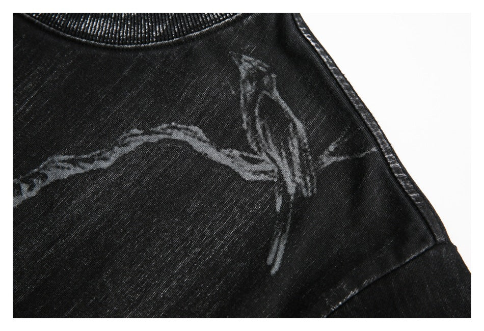 Close-up of a black shirt shoulder with a gray abstract graphic and visible seam.