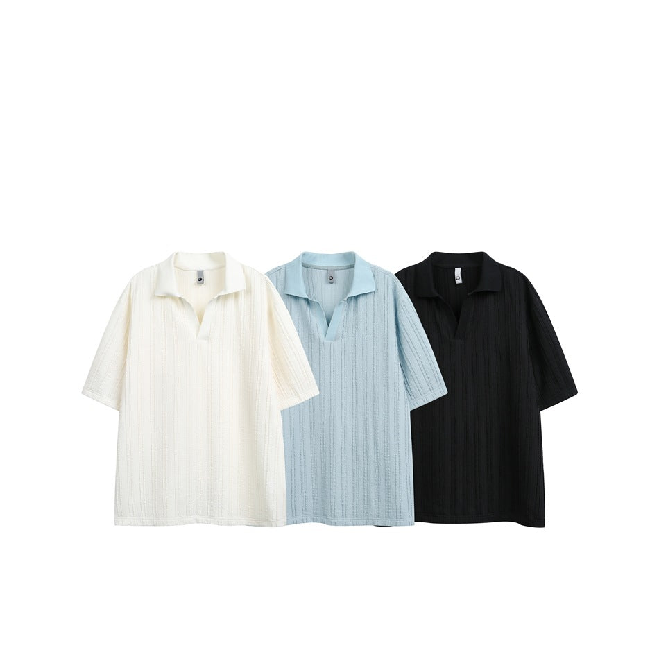 Three short-sleeve textured polo shirts shown together in ivory, pale blue, and black.