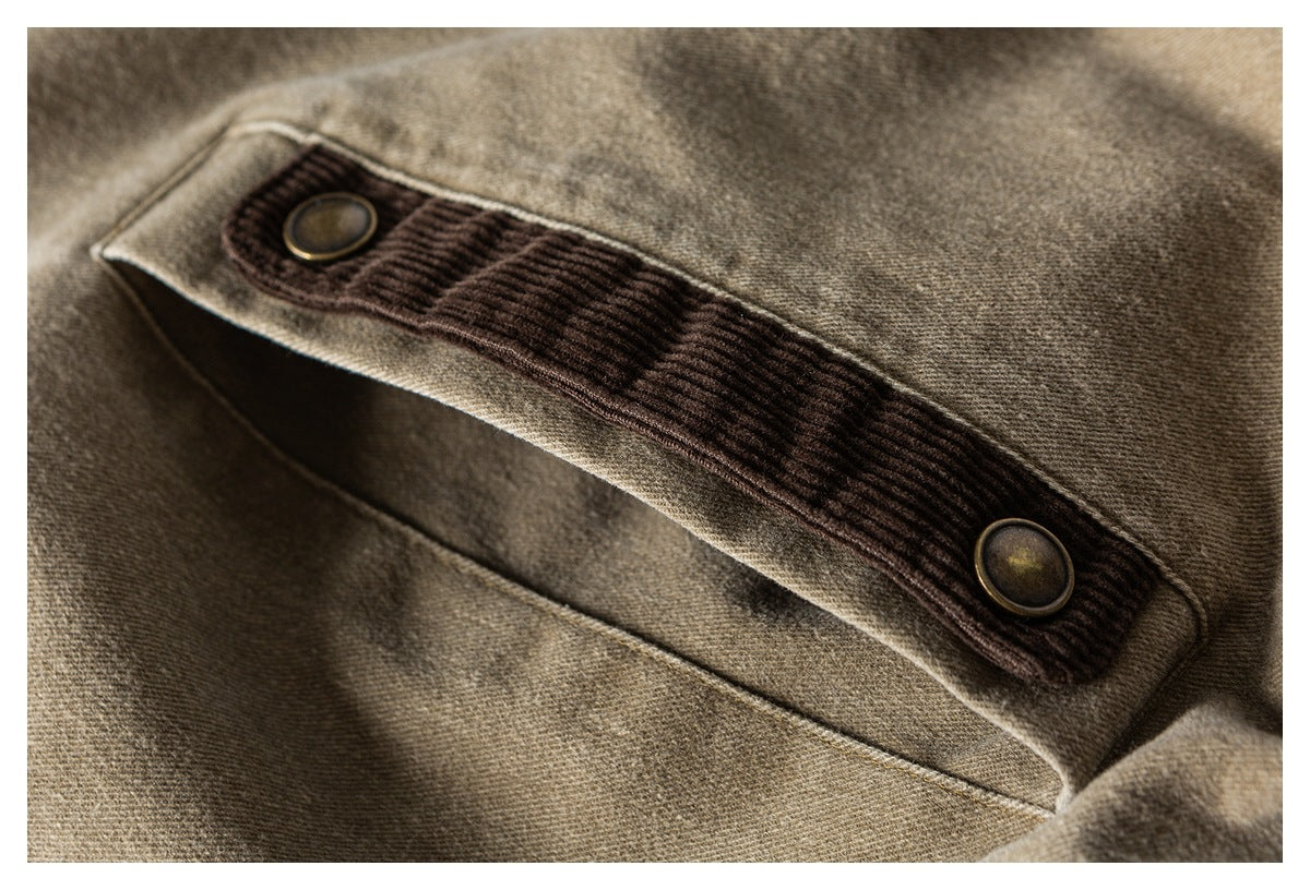 Close-up of a tan garment pocket with a dark brown ribbed flap and two round buttons.