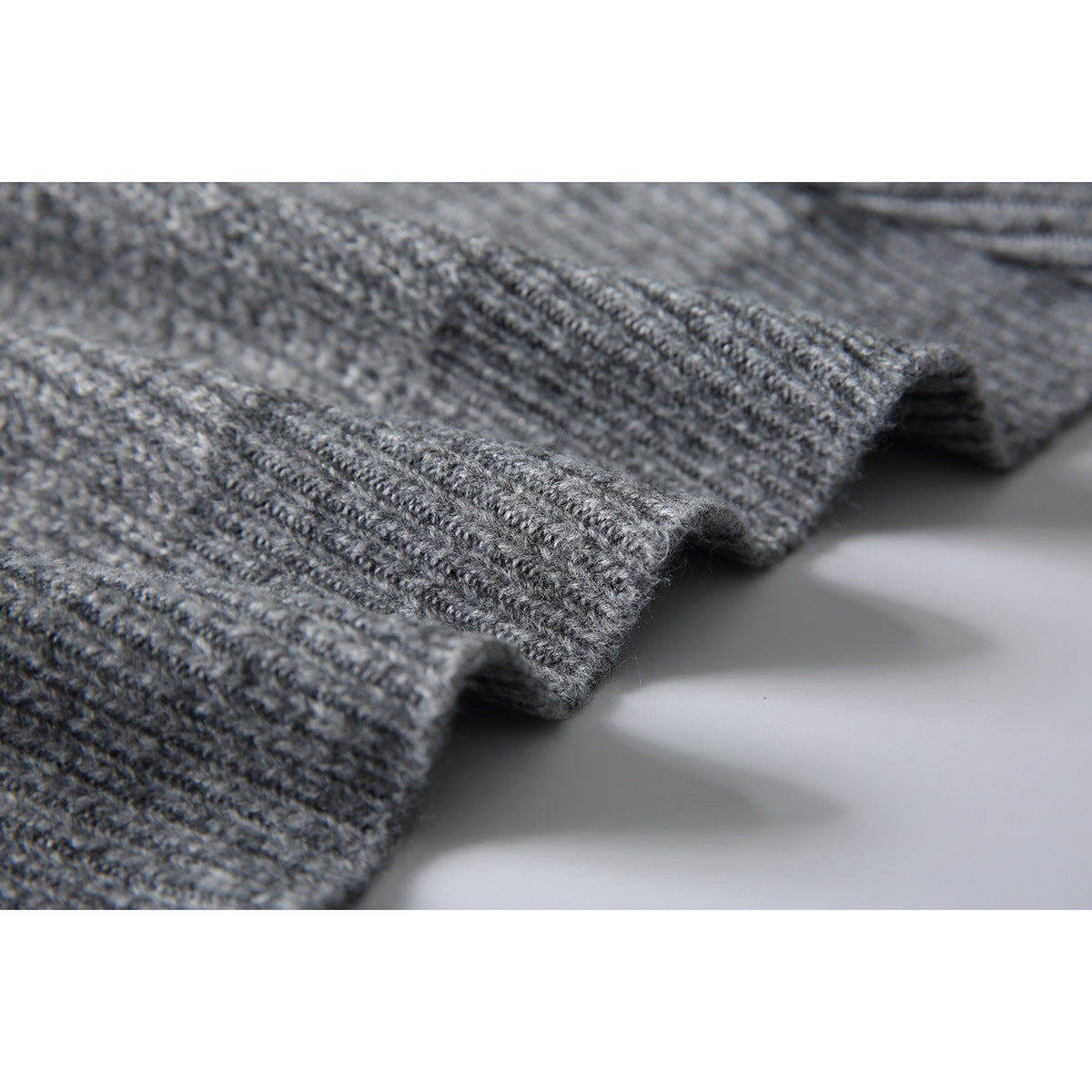 Close-up of the gray sweater's rib-knit edge and textured stitches.